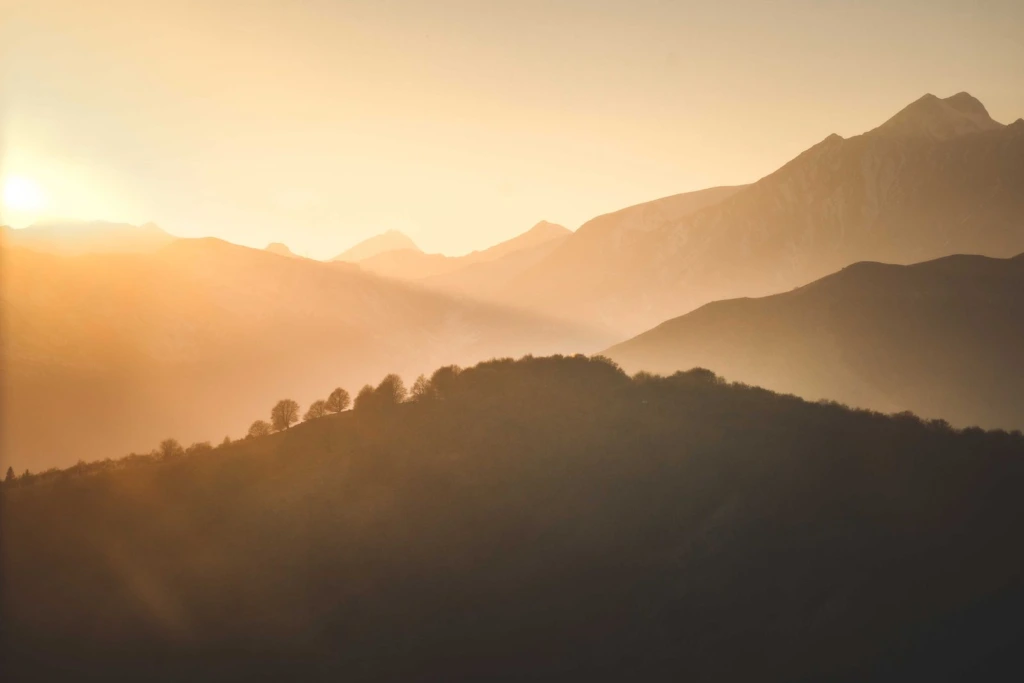 Amanecer cálido sobre montañas en calma, imagen que acompaña un artículo sobre las etapas del duelo