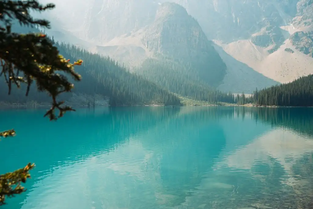 Lago en calma que refleja las montañas y el cielo