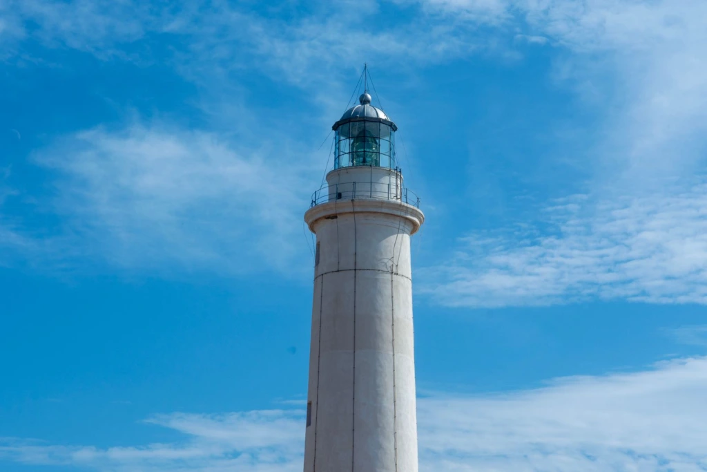 Faro blanco recortado contra un cielo azul intenso