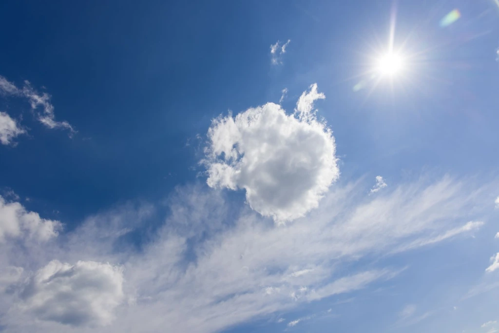 Sol brillante y nubes blancas en un cielo azul despejado