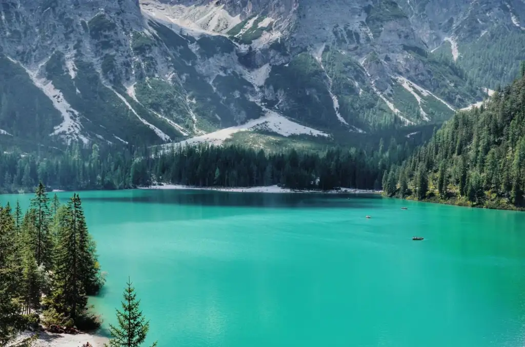 Lago de agua turquesa rodeado de bosque y montañas