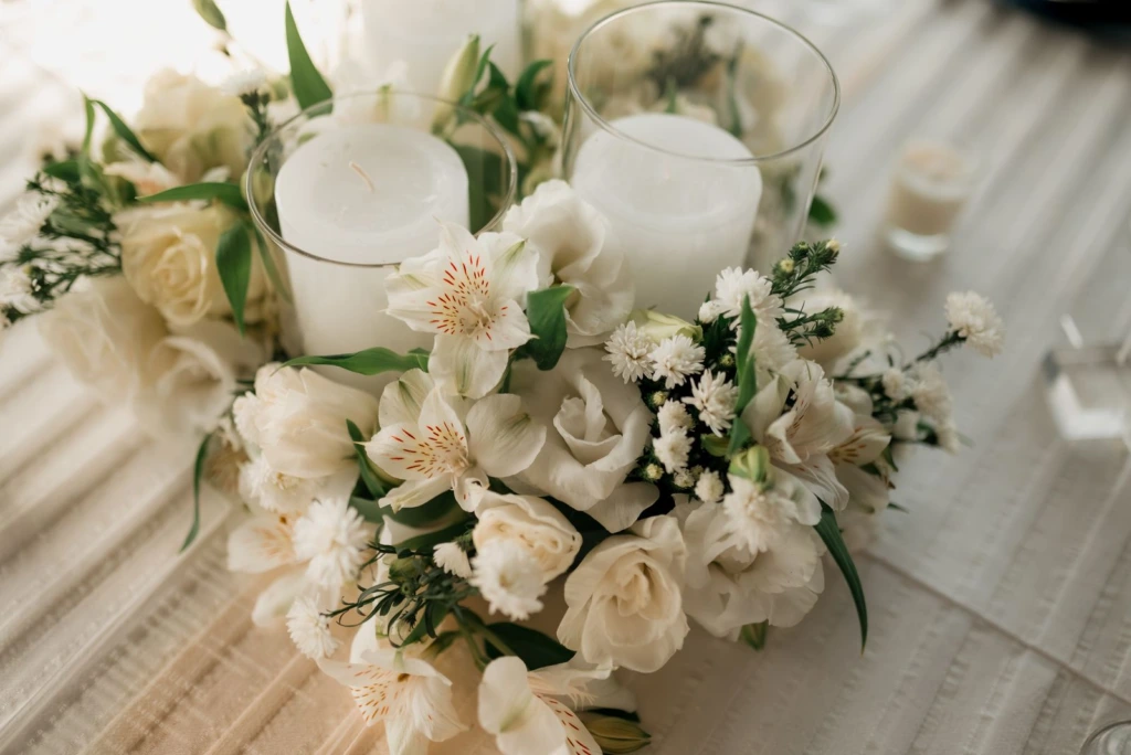 Arreglo de rosas blancas con velas encendidas